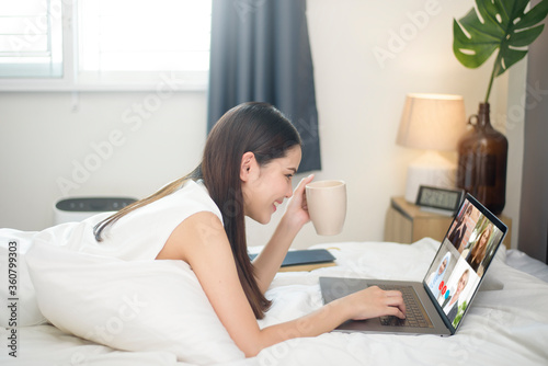 Young Woman is looking at her computer screen while business meeting through video conferencing application