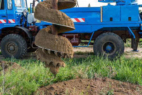Tracer tractor with auger for soil drilling for piles