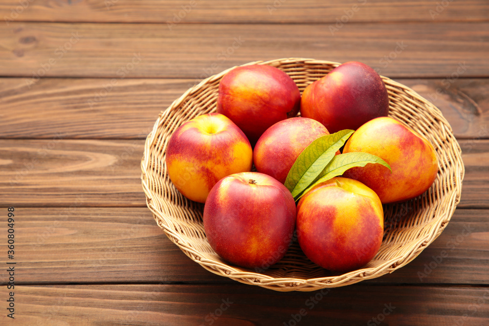 Nectarines in a basket on brown background with copy space Nectarines in a basket on brown background with copy space