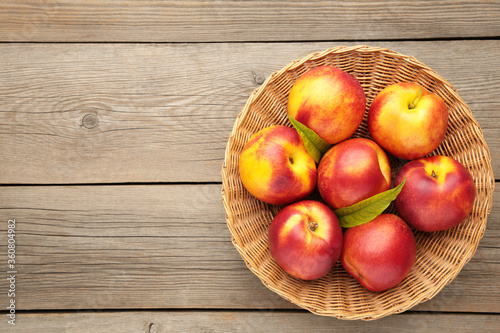 Nectarines in a basket on grey background with copy space