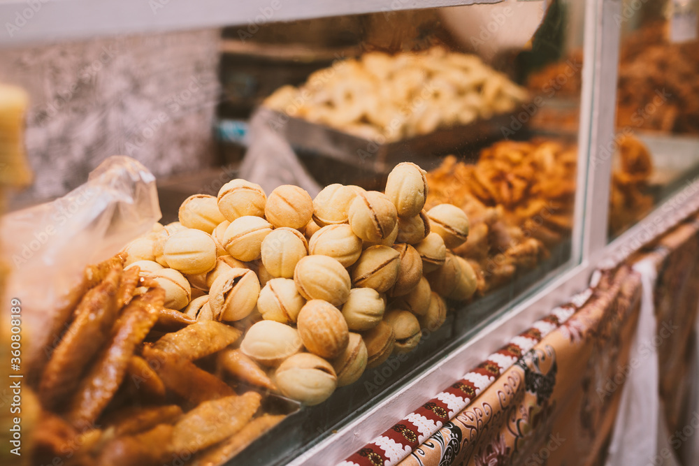 Showcase on the market with oriental sweets: baklava, cookies, nuts. Mouth-watering desserts

