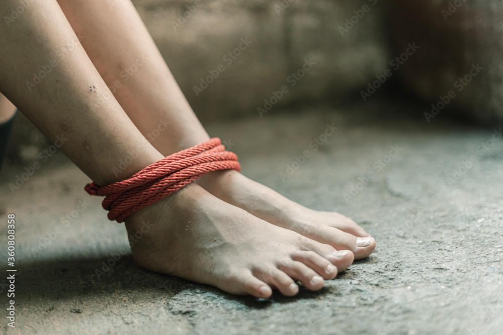 A victim foot tied up with rope. Stop violence against Women. Stock Photo |  Adobe Stock