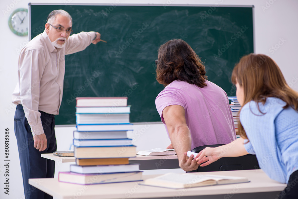 Old chemist teacher and two students in the classroom Old chemist teacher and two students in the classroom