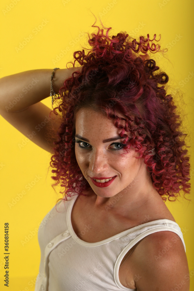 portrait of curly girl on a yellow background portrait of curly girl on a yellow background