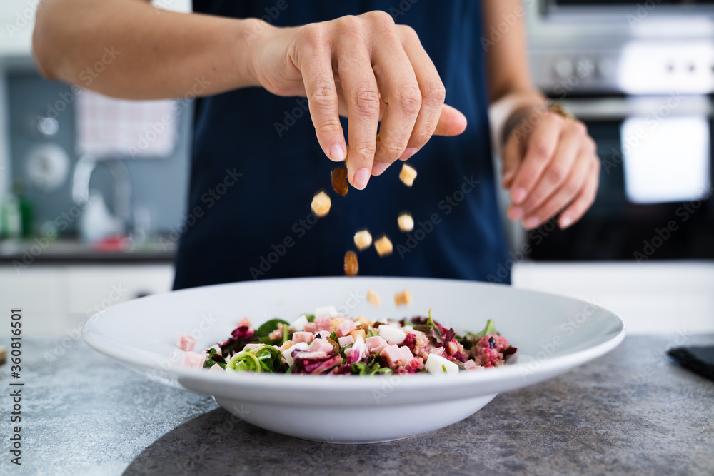 Woman Cooking Salad In Kitchen