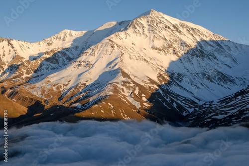 Above clouds. Mount Bazarduzu (4,467 m, the highest peak in Azerbaijan). View from Dagestan Kurush village. North Caucasus, Russia.