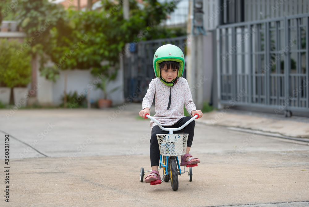Happy Asian child in helmet ride a bicycle Happy Asian child in helmet ride a bicycle