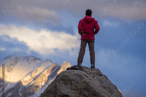Tourist man on top of the mountain in the Karakoram mountain range view from Hunza viewpoint  Gilgit Baltistan  Northern Pakistan