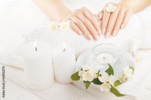beautiful french manicure with jasmine  candle and towel on the white wooden table.