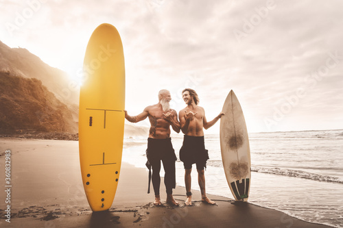 Sticker Happy friends surfing together on tropical ocean - Sporty people having fun duri