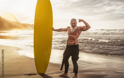 Photography Happy fit senior having fun surfing at sunset time - Sporty bearded man training