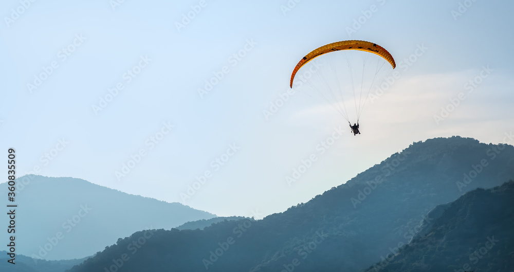 Paraglider in the sky against the background of mountains