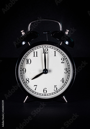 Retro vintage alarm clock on black background
