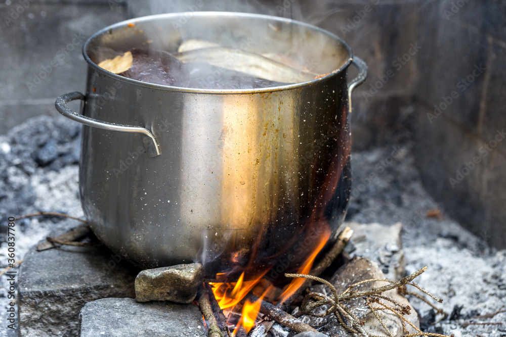 cooking outdoors, pot on wood fire in forest, picnic concept cooking outdoors, pot on wood fire in forest, picnic concept