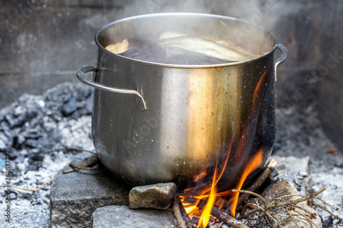 cooking outdoors, pot on wood fire in forest, picnic concept