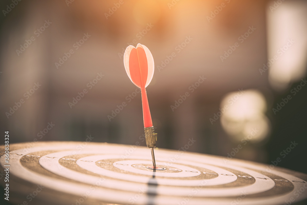 Bullseye or dart board has dart arrow throw hitting the center of a shooting target for business targeting and winning goals business concepts. Bullseye or dart board has dart arrow throw hitting the center of a shooting target for business targeting and winning goals business concepts.