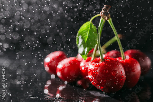Fresh red cherries with water drops on dark background, close-up view