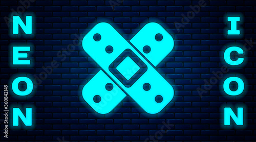 Glowing neon Crossed bandage plaster icon isolated on brick wall background. Medical plaster, adhesive bandage, flexible fabric bandage.  Vector Illustration