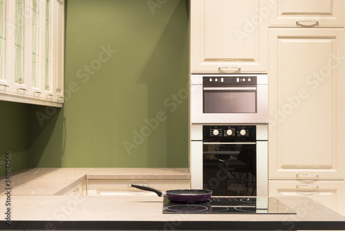 Modern kitchen room interior with furniture and pan on the stove for concept design - light home background
