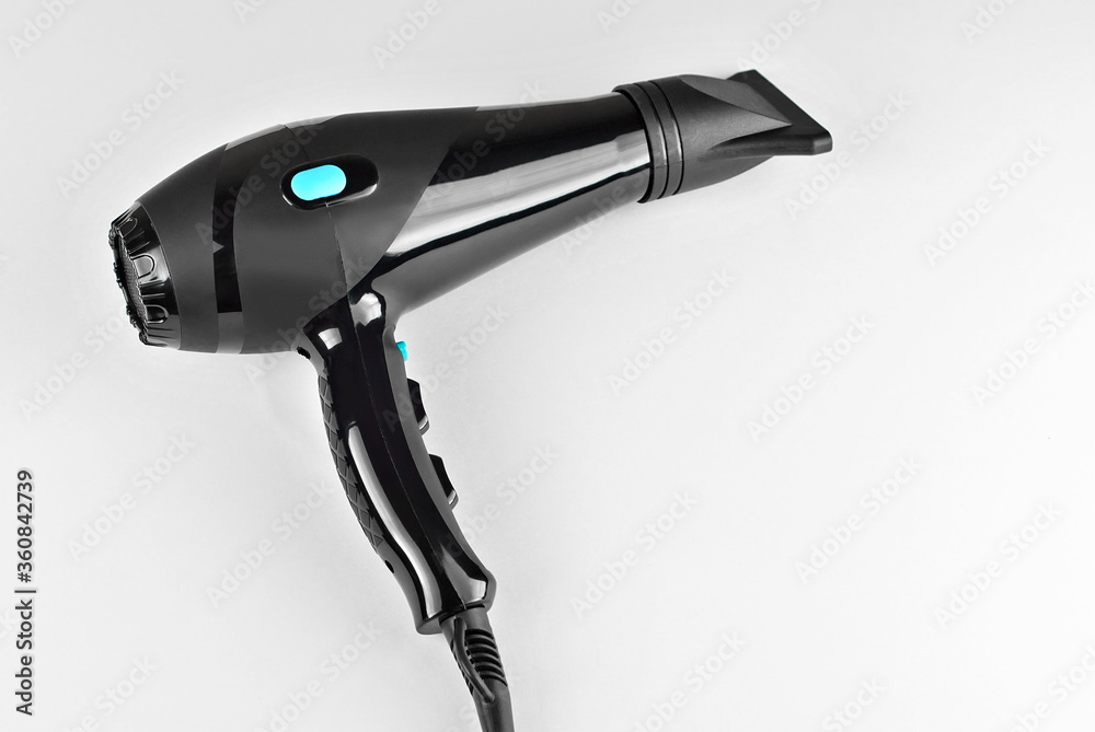 Black hair dryer isolated on a white background. Hairdresser tool close up. Black hair dryer isolated on a white background. Hairdresser tool close up.