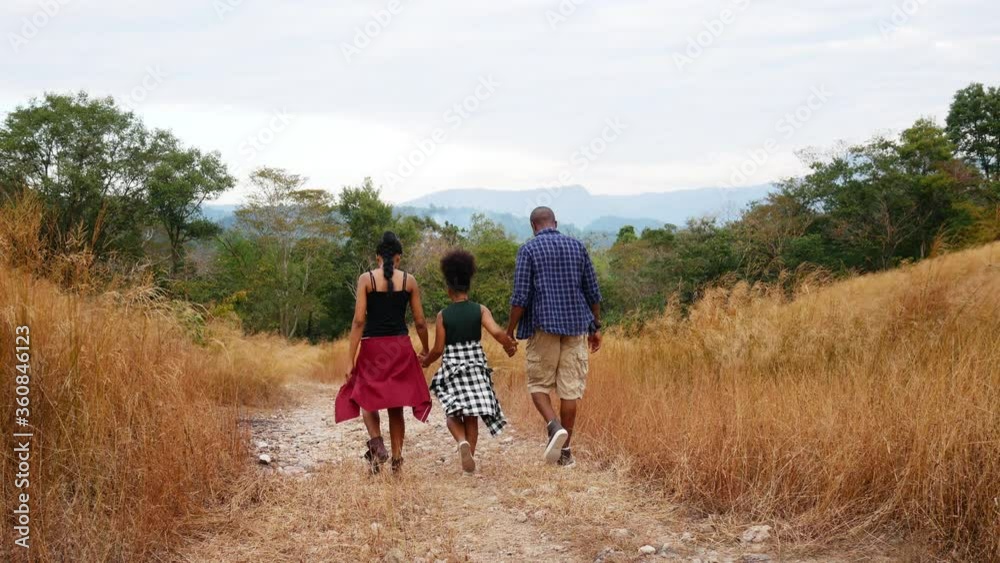 Rear view of African American family walking in the forest. Rear view of African American family walking in the forest.