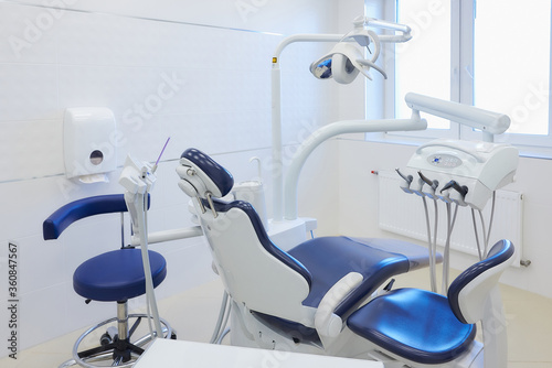 The new interior of a dental office with white and blue furniture  dental chair  high-speed drills. Dentist   s office.