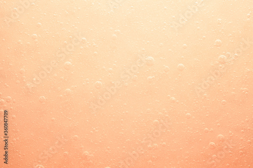 Liquid gel cosmetic serum smudge yellow orange background