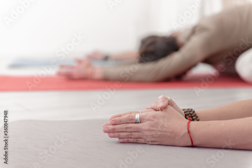 Close-up of feminine and masculine arms during meditation. Shashankasana position. Rabbit Pose. Seguence of Surya namaskar. Greeting to the Sun. How to Keep Your Arms for a Kriya or Meditation..