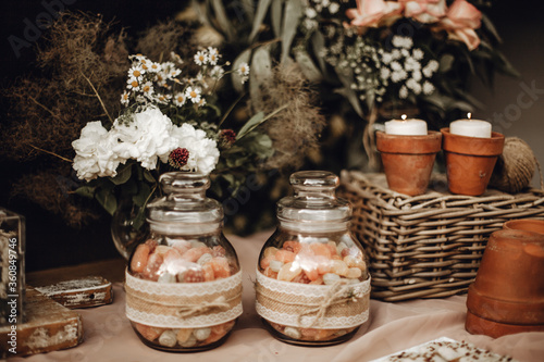 Candy bar. White wedding cake decorated by flowers standing of festive table with deserts, strawberry tartlet and cupcakes. Wedding. Reception Tartlets