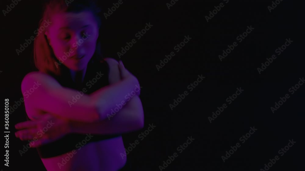 Caucasian female performing contemporary dance moves in creative lighting . High quality 4k footage