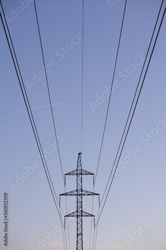 high voltage power lines and contrails of the plane