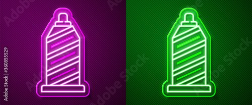 Glowing neon line Sewing thread on spool icon isolated on purple and green background. Yarn spool. Thread bobbin.  Vector Illustration