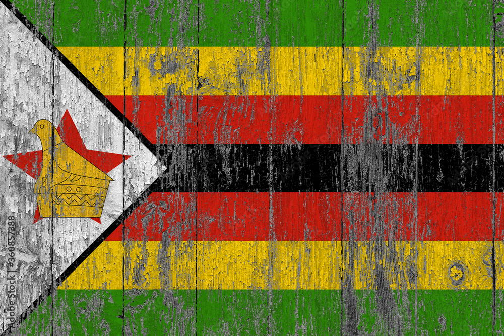 Zimbabwe flag on grunge scratched wooden surface. National vintage background. Old wooden table scratched flag surface.