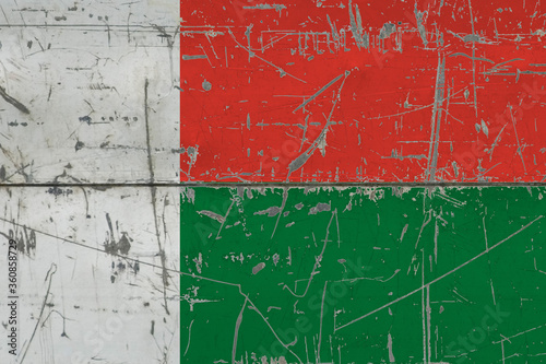 Madagascar flag painted on cracked dirty surface. National pattern on vintage style surface. Scratched and weathered concept. © sezerozger