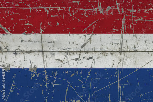 Netherlands flag painted on cracked dirty surface. National pattern on vintage style surface. Scratched and weathered concept. © sezerozger