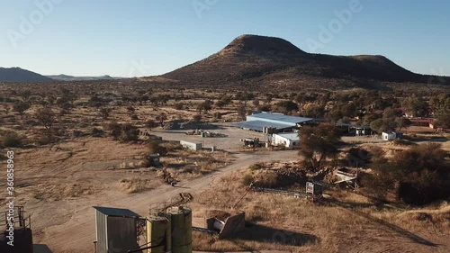 4K aerial drone video of African savanna hills, tiny settlement Aris , small stone factory near granite boulders range at B1 highway south of Windhoek in central highlands of Namibia, southern Africa photo