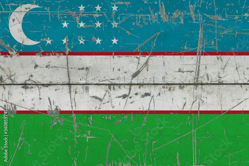 Uzbekistan flag painted on cracked dirty surface. National pattern on vintage style surface. Scratched and weathered concept. © sezerozger