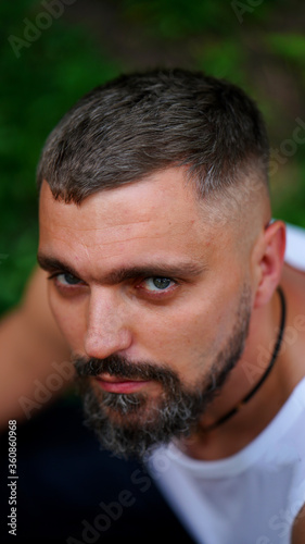 Close up portrait of bearded man posing confidently and looking haughtily
