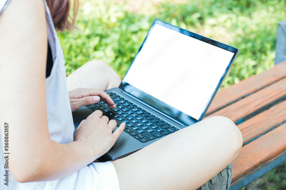 Naklejka premium closeup female hands working or studying online on laptop in park and enjoying time alone in nature