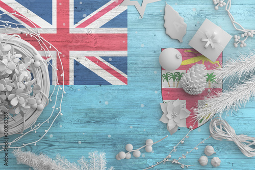 Fiji flag on wooden table with snow objects. Christmas and new year background  celebration national concept with white decor.
