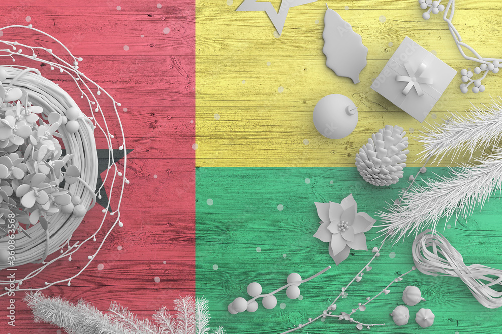 Guinea flag on wooden table with snow objects. Christmas and new year background, celebration national concept with white decor.