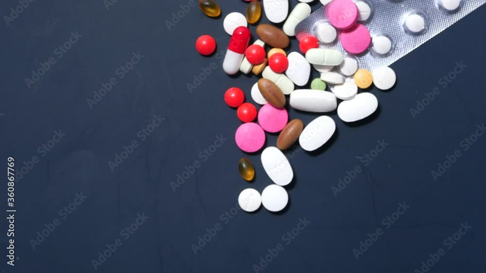 colorful pills spilling on dark background top down colorful pills spilling on dark background top down