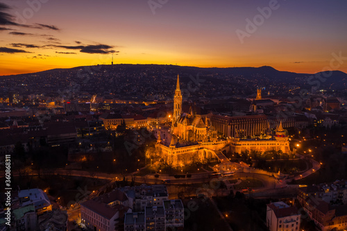 Aerial drone shot of lighted Matthias Churh Fisherman's Bastion on Buda Hill in Budapest sunset time
