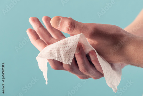 A man wipes his hands with a wet wipe