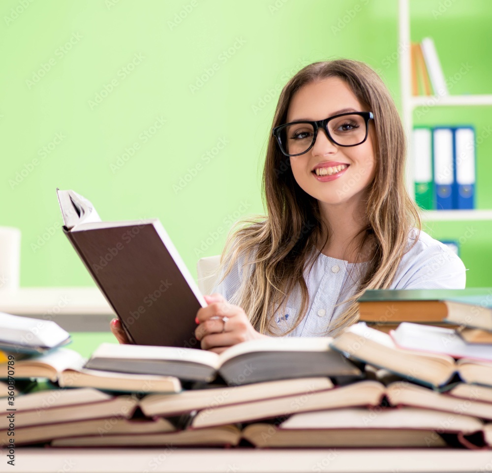 Young female student preparing for exams with many books Young female student preparing for exams with many books