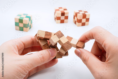 Фотография hand hold wooden puzzle cube isolated on white background