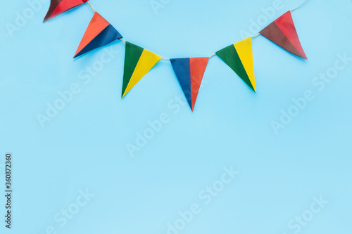 blue background with flags, multi-colored triangular flags hanging at the top, there is space for text, front view