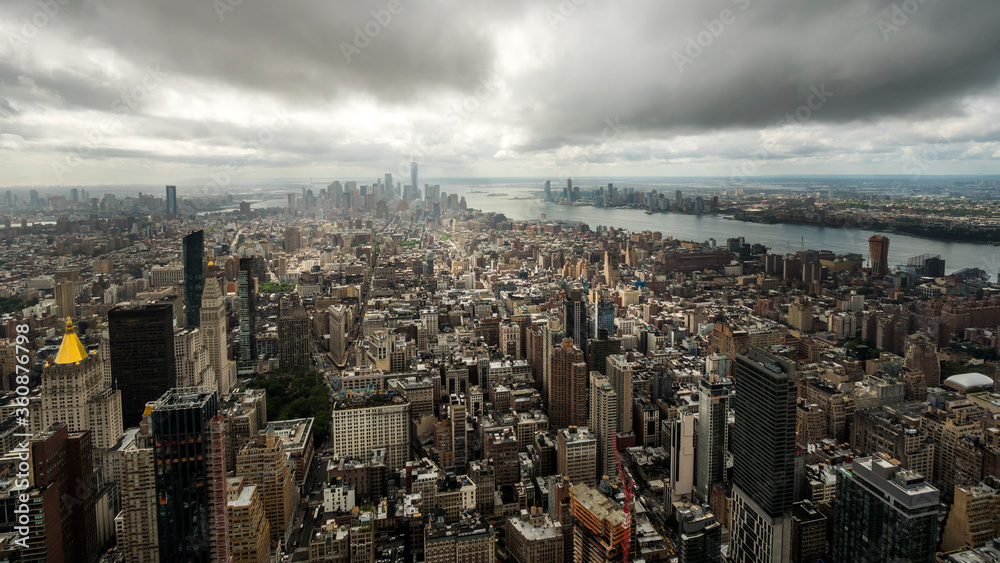 View of the Manhattan business district in New York, USA. Dramatic sky over the city