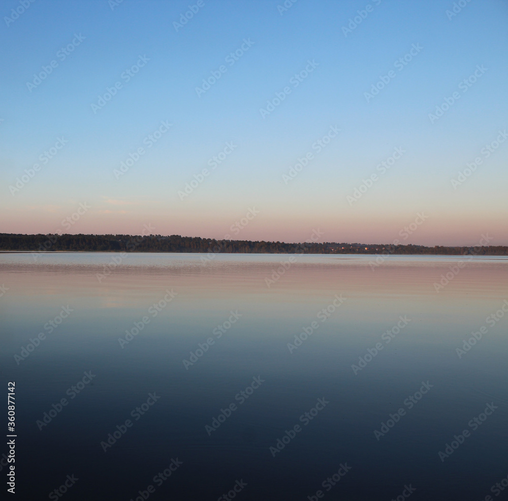 The horizon line where the surface of the lake passes into the twilight sky