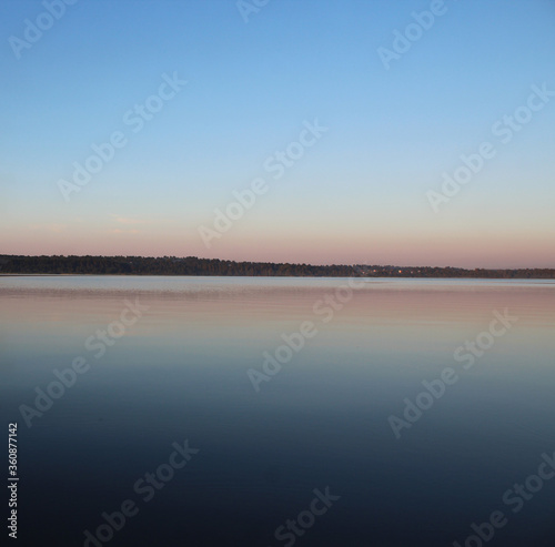 The horizon line where the surface of the lake passes into the twilight sky